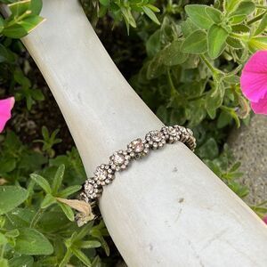 Glass stone circular bracelet with flower detail.